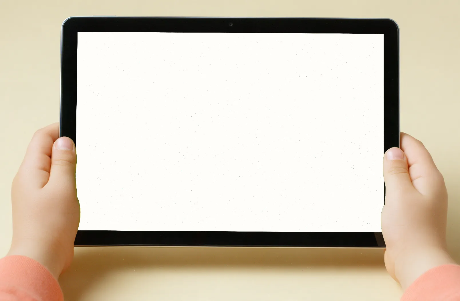 Dziecięce dłonie trzymają tablet z grą Luma